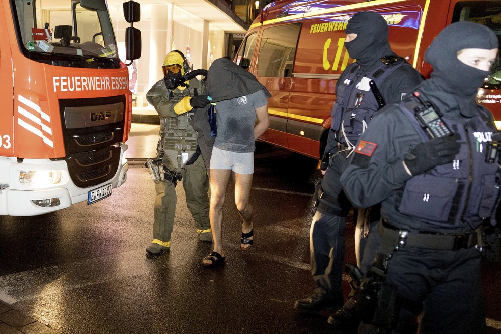 Homem acusado de planejar ataque químico é levado pelos oficiais para fora de sua casa na Alemanha — Foto: Karsten Wickern/dpa via AP