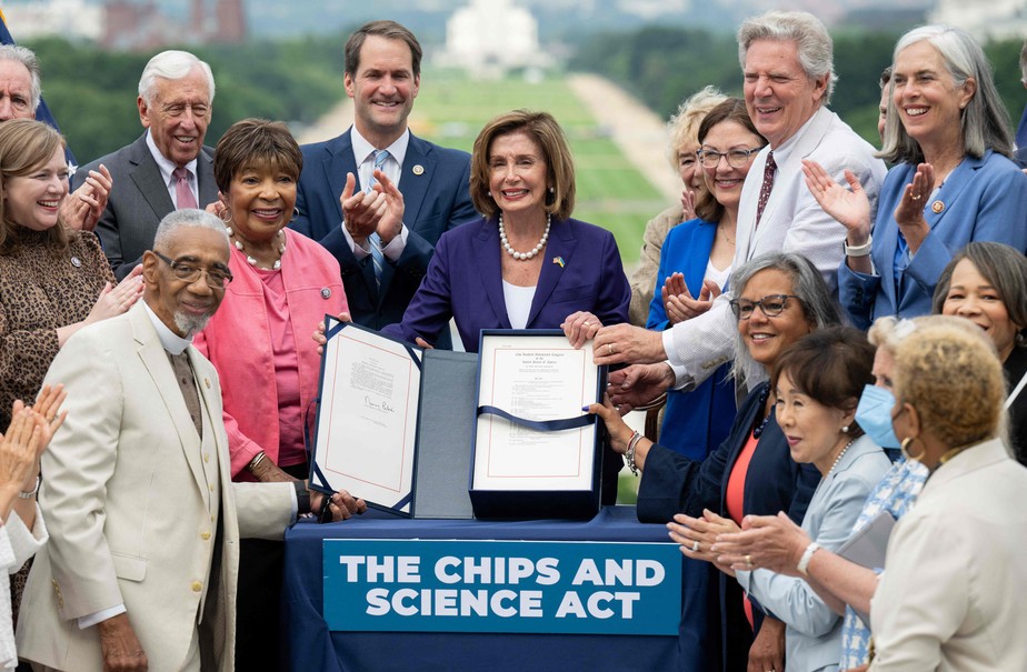 A presidente da Câmara dos EUA, Nancy Pelosi, ao lado de membros do Congresso, segura o Projeto de Lei Chips e Ciência, depois de assiná-lo durante cerimônia em Washington, DC