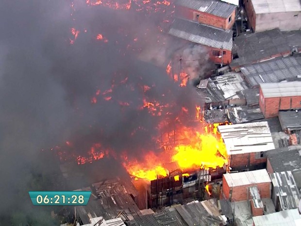 Às 6h30, bombeiros trabalhavam para evitar que fogo se alastrasse em favela de Sapopemba, na Zona Leste de São Paulo, na manhã desta sexta (23) (Foto: Reprodução/TV Globo)