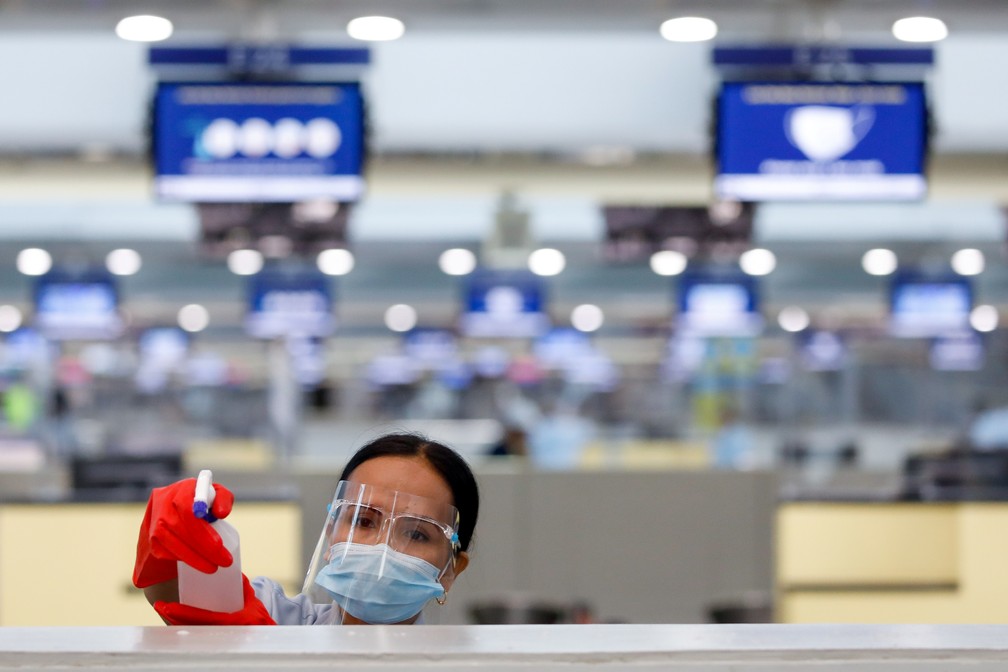 Mulher higieniza bancada no principal aeroporto das Filipinas, perto de Manila, nesta quinta-feira (9) — Foto: Eloisa Lopez/Reuters