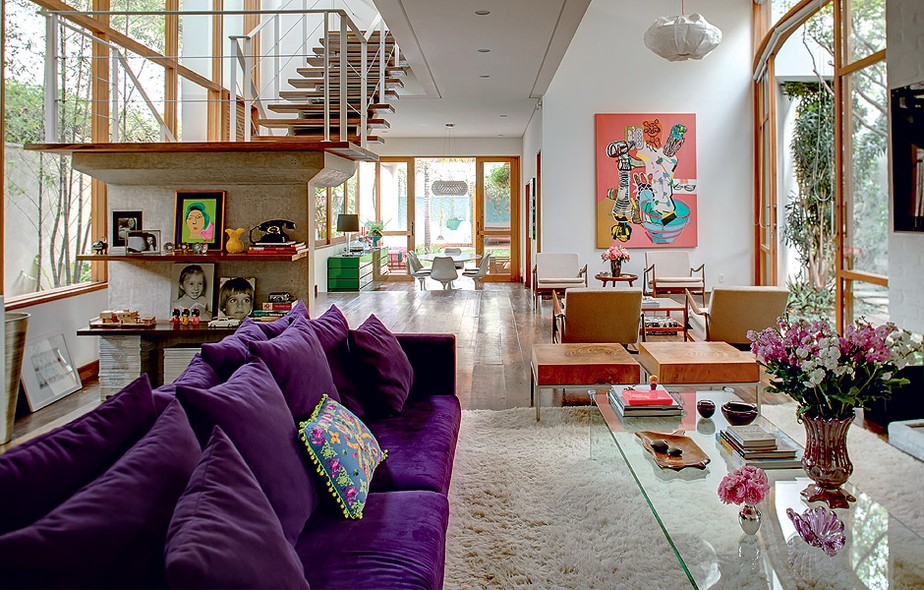 Na sala ampla e clara, o confortável sofá púrpura reina absoluto. Objetos em tons de rosa predominam nos detalhes