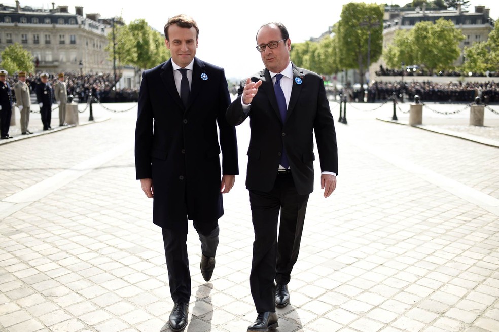 O presidente da França, François Hollande (dir.) conversa com seu sucessor em evento um dia após a vitória de Macron (Foto: Stephane de Sakutin/AFP)