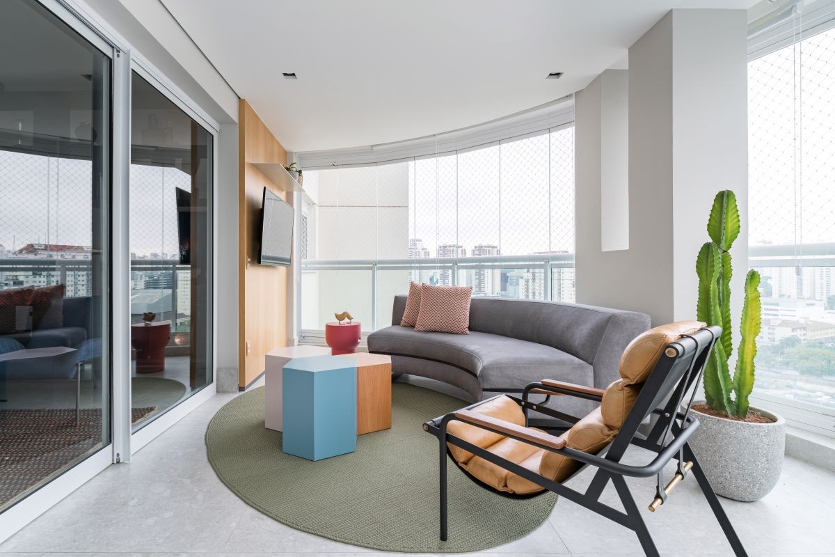 VARANDA | O sofá acompanha a curvatura do prédio para aproveitar o espaço da melhor forma (Foto: Divulgação / Kadu Lopes)