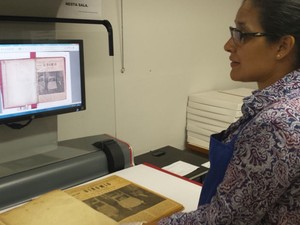 Coordenadora da Divisão de Coleções Especiais da Biblioteca da UFMG, Diná Araújo, demonstra como o Binõmio foi digitalizado (Foto: Thais Pimentel/G1)