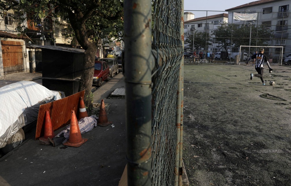 O corpo de Valnir Mendes da Silva, de 62 anos, é visto em uma calçada da comunidade de Arara, no Rio de Janeiro, em 17 de maio, onde morreu após moradores solicitarem ajuda dos serviços de emergência enquanto ele apresentava problemas respiratórios  — Foto: Ricardo Moraes/Reuters