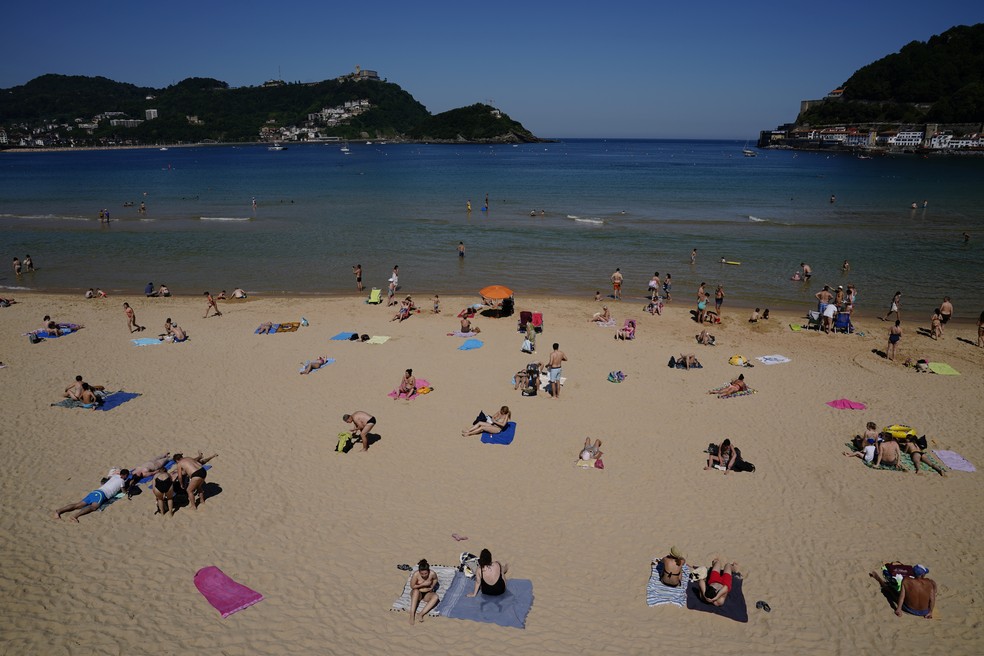 Banhistas tomam sol respeitando o distanciamento social na praia de La Concha, em San Sebastian, na Espanha, no sábado (30) — Foto: Vincent West/Reuters
