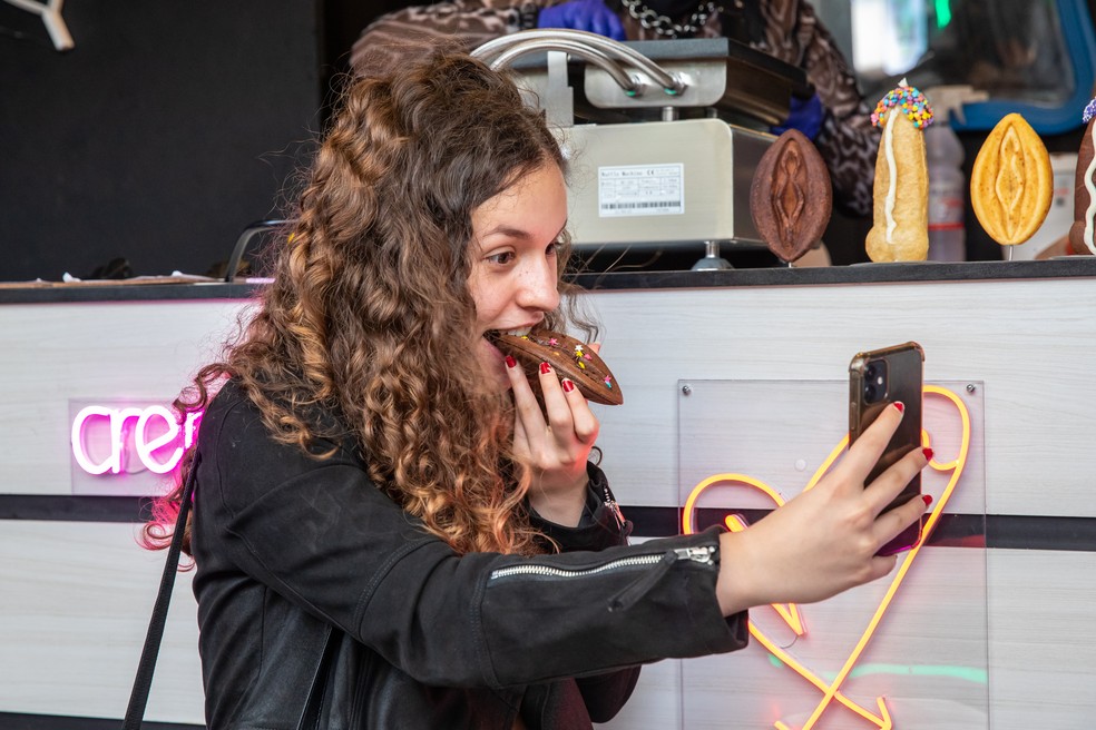 A estudante Giulia Aquino, de 18 anos, prova a crepepeka de chocolate da “Assanhadxs Erotic Food” e registra a cena no Instagram. — Foto: Celso Tavares/g1 