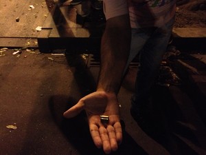 Manifestante mostra cápsula de bala de verdade usada por policiais durante confronto no Centro do Rio (Foto: Priscilla Souza/G1)