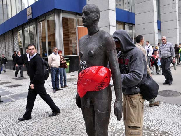 Homem tenta cobrir nudez de estátua com sacola plástica no Centro de SP (Foto: Cris Faga/AE)