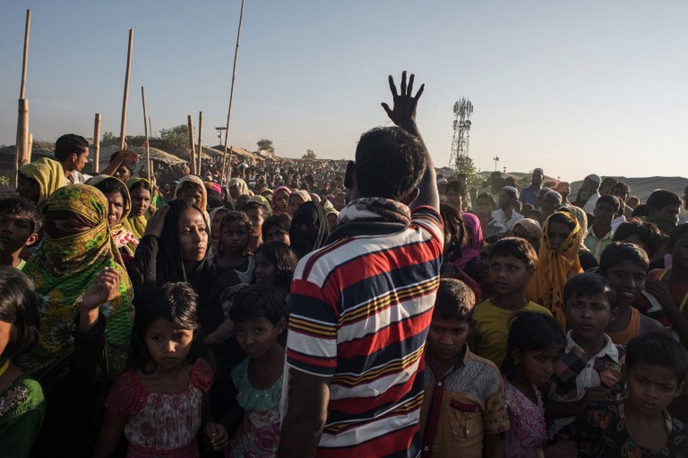 Homem sinaliza para grupo de refugiados que a ajuda foi suspensa no Kutupalong, em Cox's Bazar, na quinta-feira (30)  (Foto: Ed Jones / AFP)
