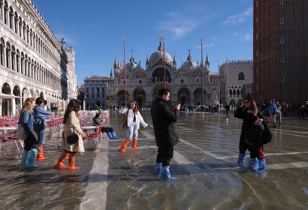 Turistas usam galochas plásticas para visitar a Praça San Marco em Veneza em 5 de novembro de 2021 — Foto: Manuel Silvestri/Reuters