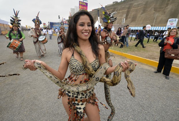 Dançarina desfilou com duas jiboias durante a abertura de uma feira gastronômica em Lima (Foto: Cris Bouroncle/AFP)