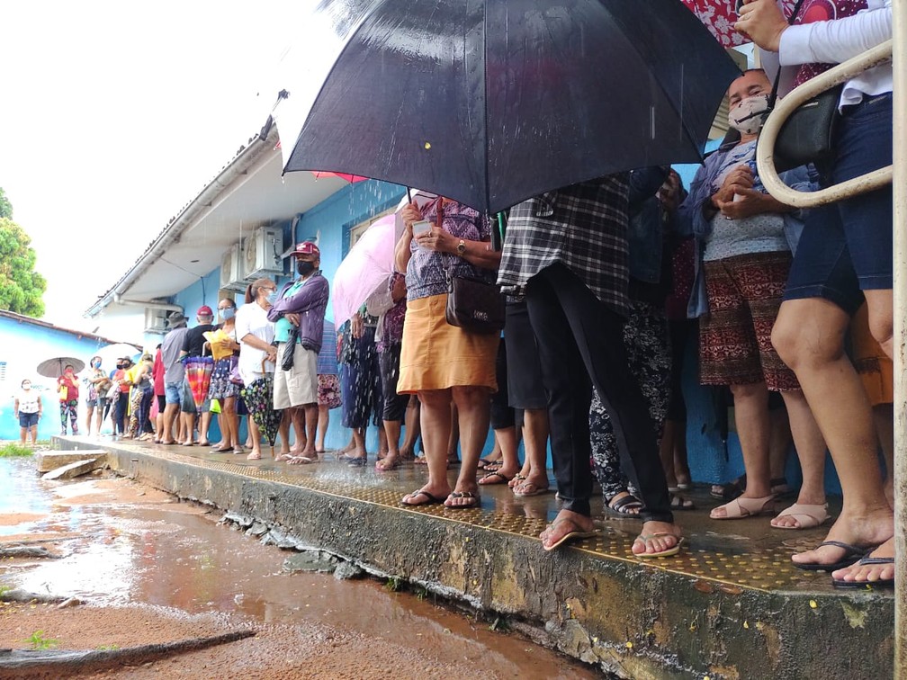 Idosos se abrigam da chuva embaixo de marquise à espera de vacina contra Covid-19 em Natal — Foto: Lucas Cortez/Inter TV Cabugi