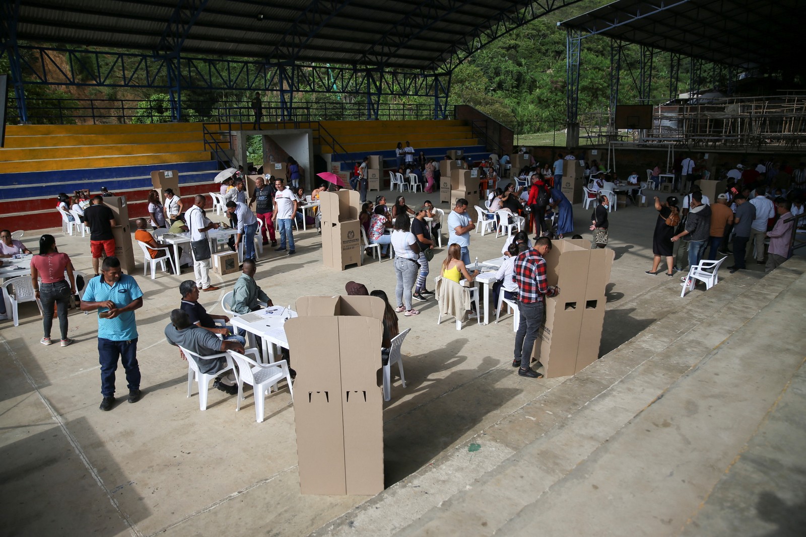 Pessoas votam durante o primeiro turno da eleição presidencial, em Suárez — Foto: Luisa Gonzalez/REUTERS