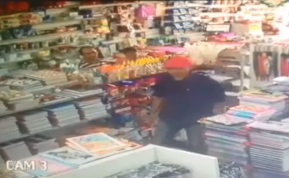 Suspeito, usando boné vermelho, foi identificado pelas câmeras de segurança do local. (Foto: Reprodução)