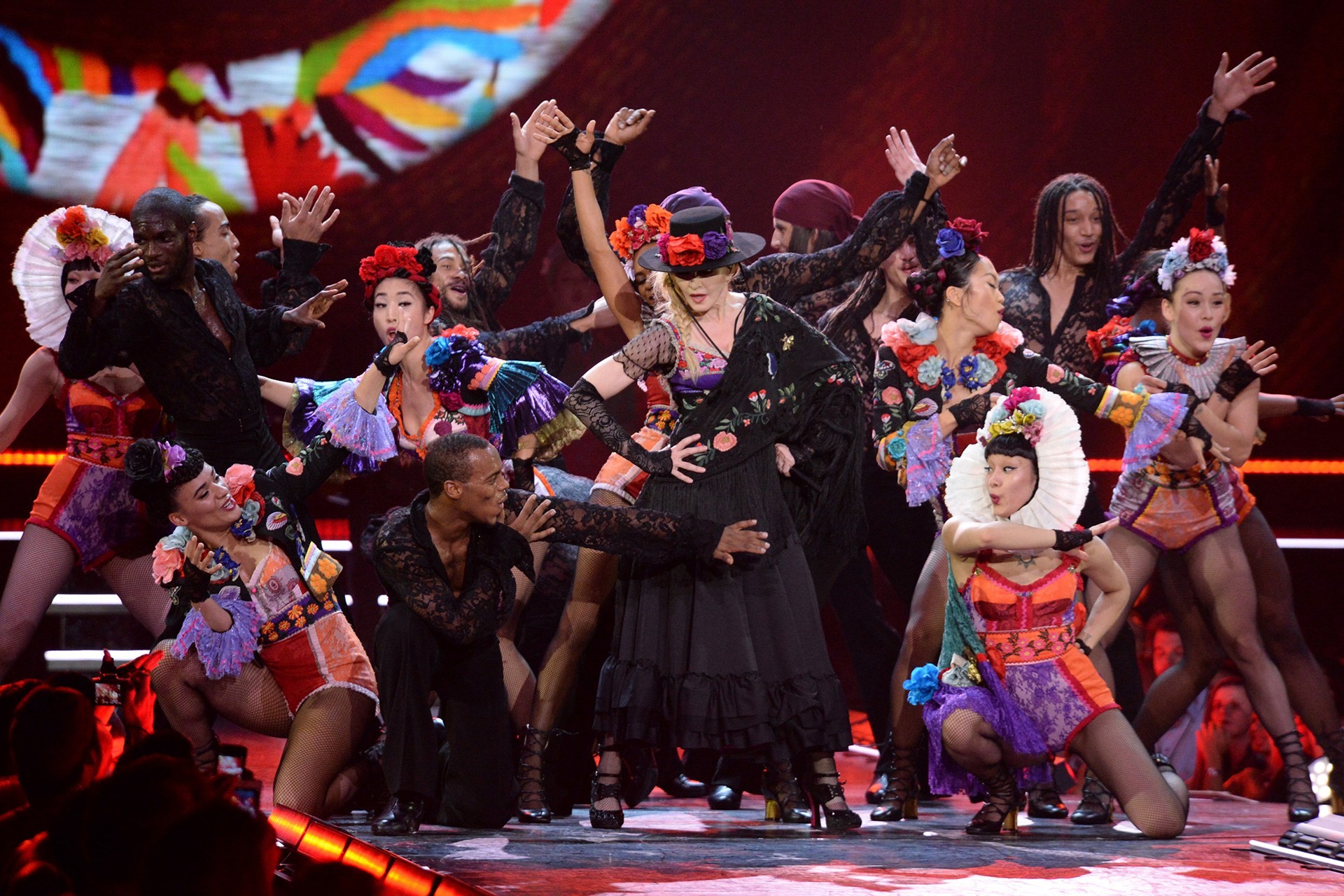 Madonna no palco com seus dançarinos na turnê mundial 
