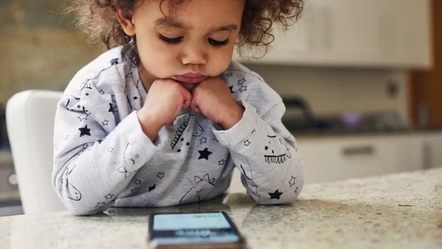 Crianças de 2 a 5 anos devem ter acesso a, no máximo 1 hora de celular, tablet ou computador por dia (Foto: Getty Images via BBC)