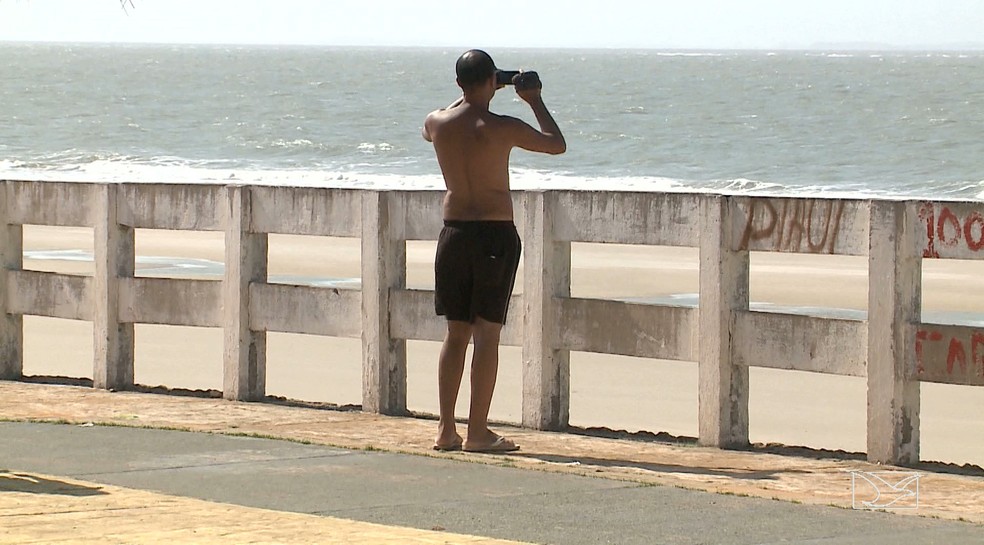 Turista Gilmar Silva não pôde entrar na água por causa da mancha de sujeira que ia em direção a praia. (Foto: Reprodução/TV Mirante)
