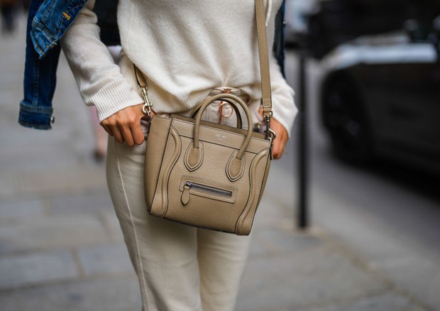 PARIS, FRANCE - JUNE 25: A guest wears a blue denim jacket, a white wool ribbed pullover, a beige shiny grained leather  LUGGAGE MINI crossbody bag from Celine, white denim jeans pants, outside Officine Générale, during Paris Fashion Week - Menswear Sprin (Foto: Getty Images)