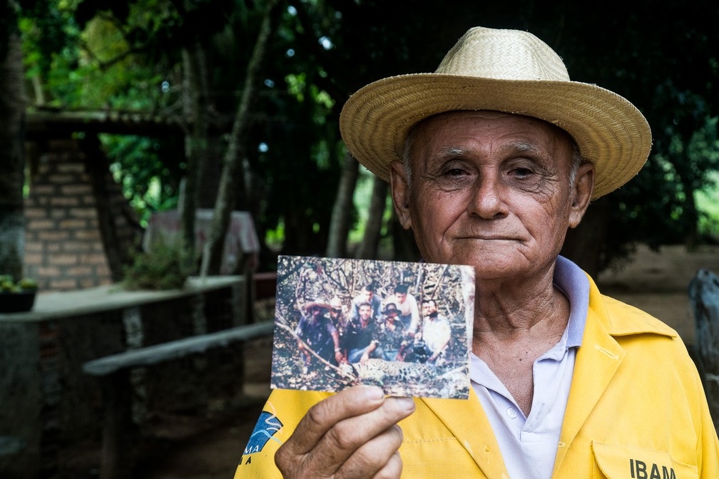 Tutu mostra uma foto antiga de sua época como funcionário do Ibama, quando ajudava biólogos a capturar onças para fins científicos — Foto: Eduardo Palacio/G1