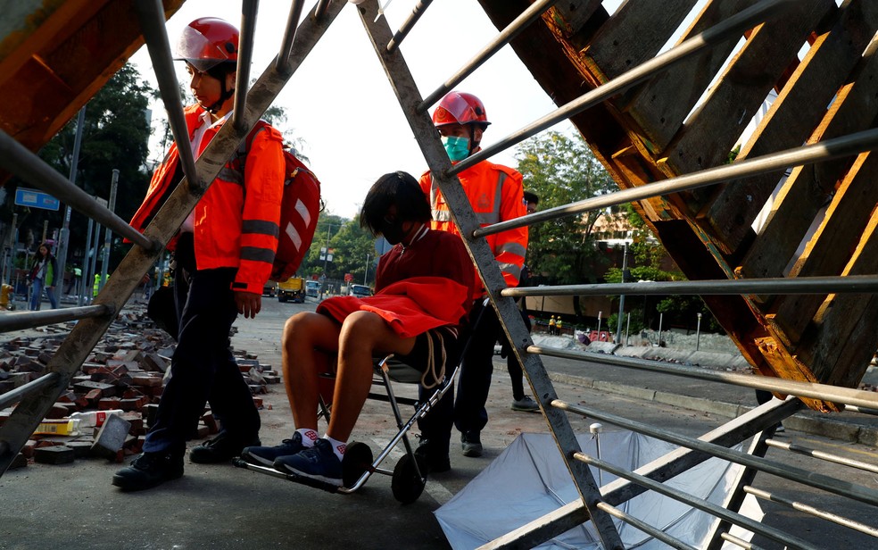 Manifestante é transportado para receber atendimento médico após deixar o campus da Universidade Politécnica de Hong Kong, na quarta-feira (20) — Foto: Reuters/Thomas Peter
