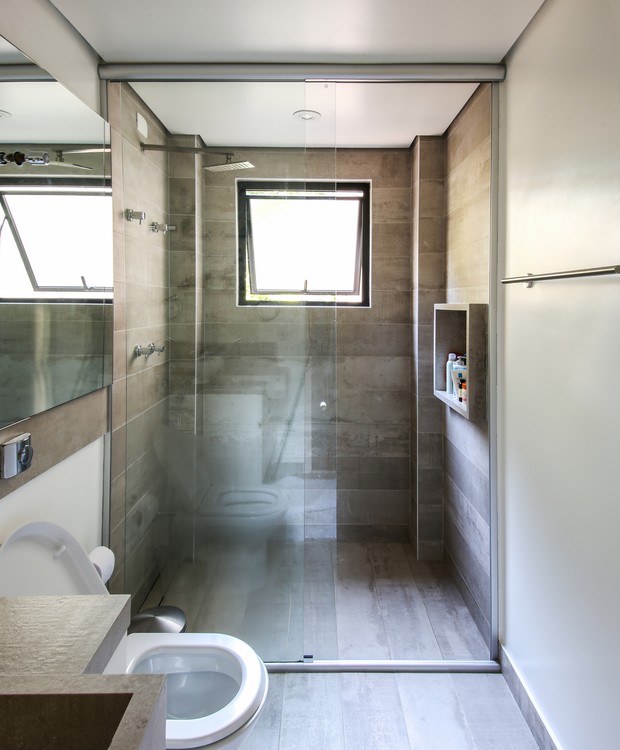  BANHEIRO | O banheiro segue a mesma característica neutra de todo o apê. Piso de porcelanato de concreto cinza da Portobello (Foto: Marcelo Macedo/ Divulgação)