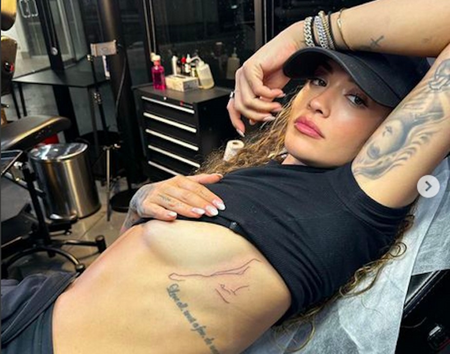 A cantora Rita Ora mostrando sua nova tatuagem