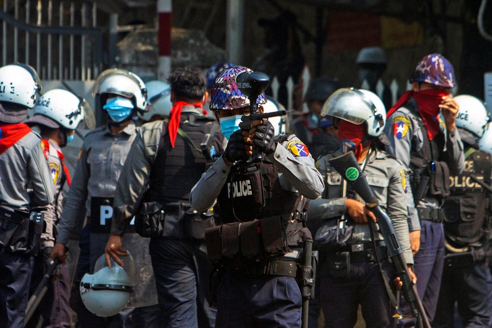 Policial atira balas de borracha na direção de manifestantes durante protesto em Yangon, em Mianmar, neste domingo (28) — Foto: Stringer/Reuters
