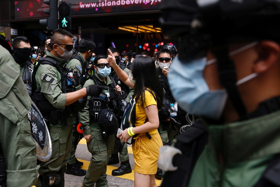 Um manifestante pró-democracia discute com a polícia em Hong Kong, nesta quinta-feira (1º), antes de um protesto pela libertação de doze ativistas presos no mar enquanto tentavam fugir para Taiwan — Foto: Tyrone Siu/Reuters