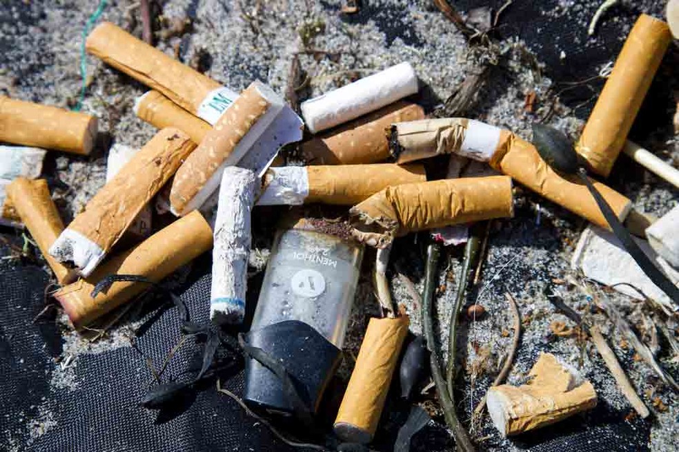 Bitucas de cigarro e vaporizador encontrados em praia.  — Foto:  Brian Yurasits/Unplash
