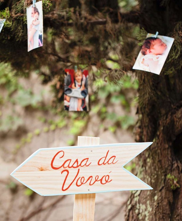 Fotos dos bebês em um varal improvisado e a dica para a casa da vovó no quintal. Placa Festa de Brincar (Foto: Elisa Correa)