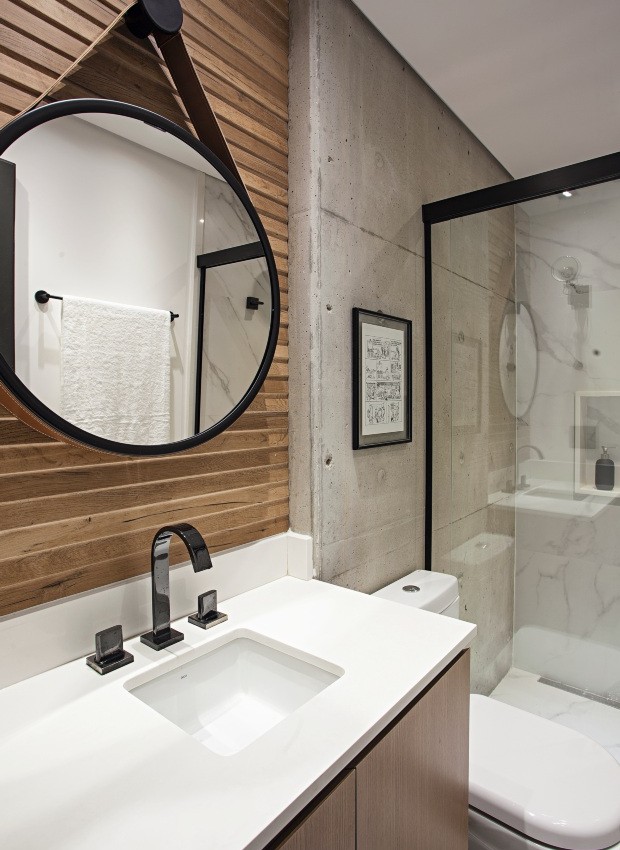 Banheiro. Com bancada de quartzo PKO branco puro, tem parede revestida por porcelanato com efeito de madeira da Portobello e espelho da Tok & Stok (Foto: Gui Morelli / Divulgação)
