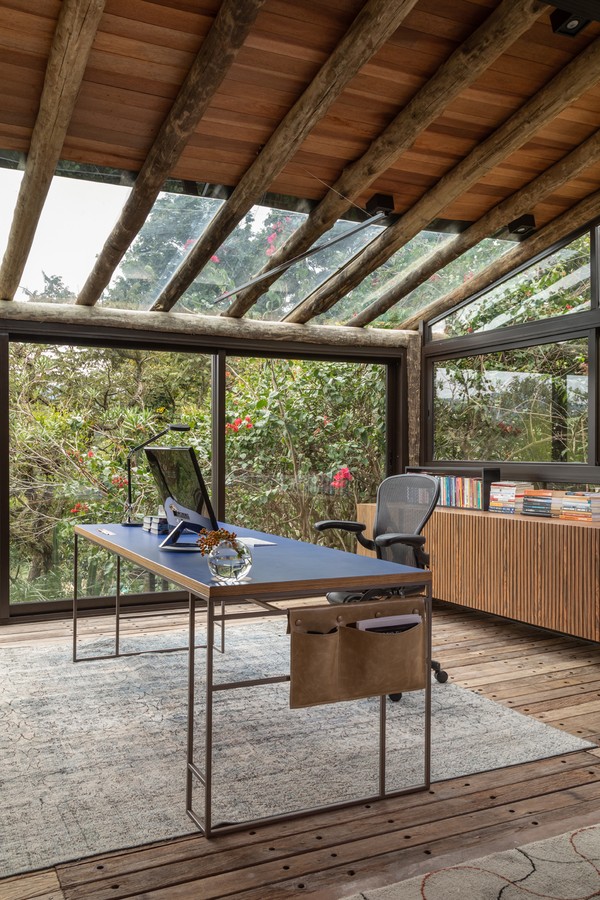 Cabana de 100 m² exibe sala com lareira e home office na varanda (Foto: Evelyn Müller)