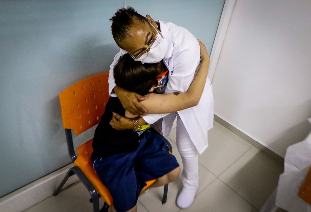 Criança abraça enfermeira após vacinação contra a Covid-19 em Osasco. — Foto: ALOISIO MAURICIO/FOTOARENA/ESTADÃO CONTEÚDO