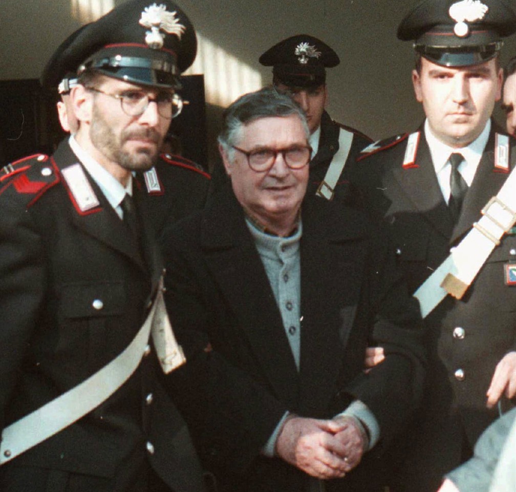 Foto de 16 de janeiro de 1996 mostra o ‘chefe dos chefes’ da máfia siciliana, Toto Riina, sendo escoltado até o tribunal em Bolonha, na Itália  (Foto: Gianni Schicchi/ AP)