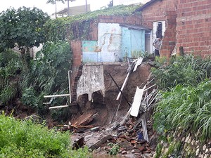 Enxurrada levou parte de muro e ameaça desabar casa na capital (Foto: Tita Mara Teixeira/G1)