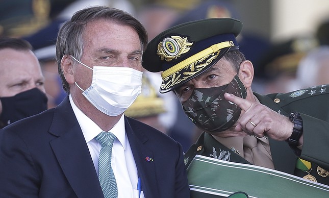 O então comandante do Exército e hoje ministro da Defesa, Paulo Sérgio Nogueira (à dir.), ao lado do presidente Bolsonaro durante cerimônia do dia do soldado