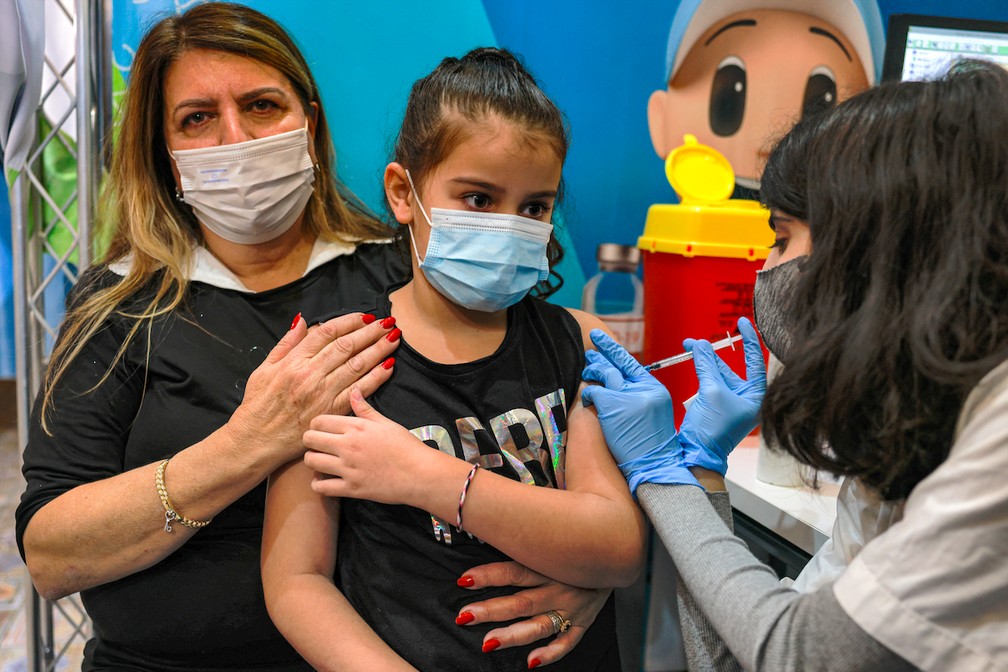 Menina é vacinada em Israel contra a Covid-19 em 22 de novembro de 2021 — Foto: MENAHEM KAHANA / AFP