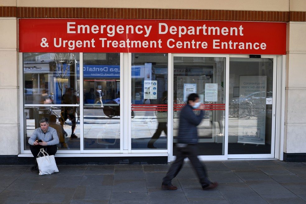 Homem com máscara protetora passa pelo Departamento de Emergência e do Centro de Tratamento Urgente do hospital Chelsea e Westminster, no centro de Londres, na segunda-feira (23)  — Foto: Daniel Leal-Olivas / AFP