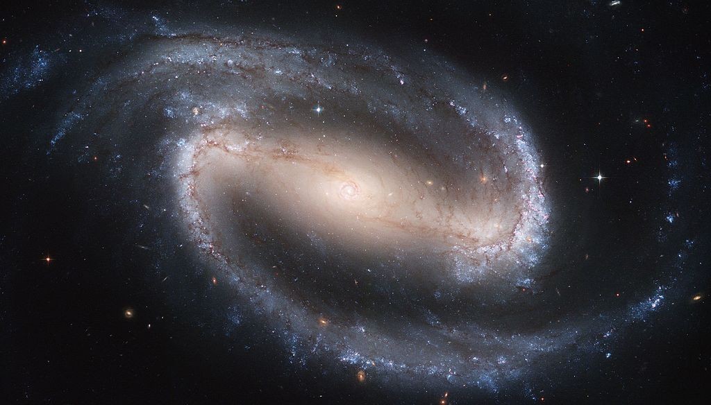 Galáxia espiral barrada, onde aparecem os braços espirais azuis,  locais de ativa formação de estrelas novas (Foto: Wikipedia Commons)