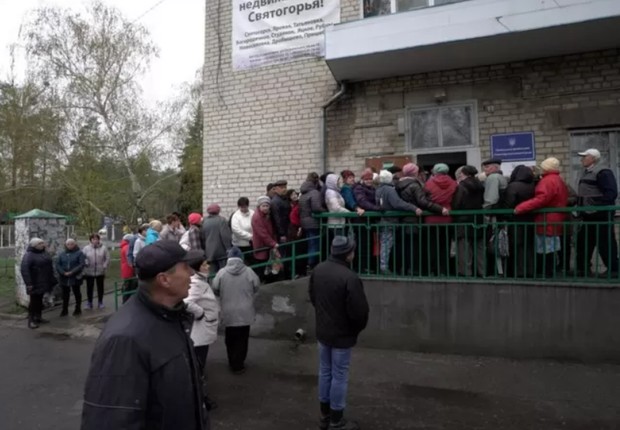 BBC - Moradores da região de Donbas fazem fila para receber comida (Foto: BBC News)
