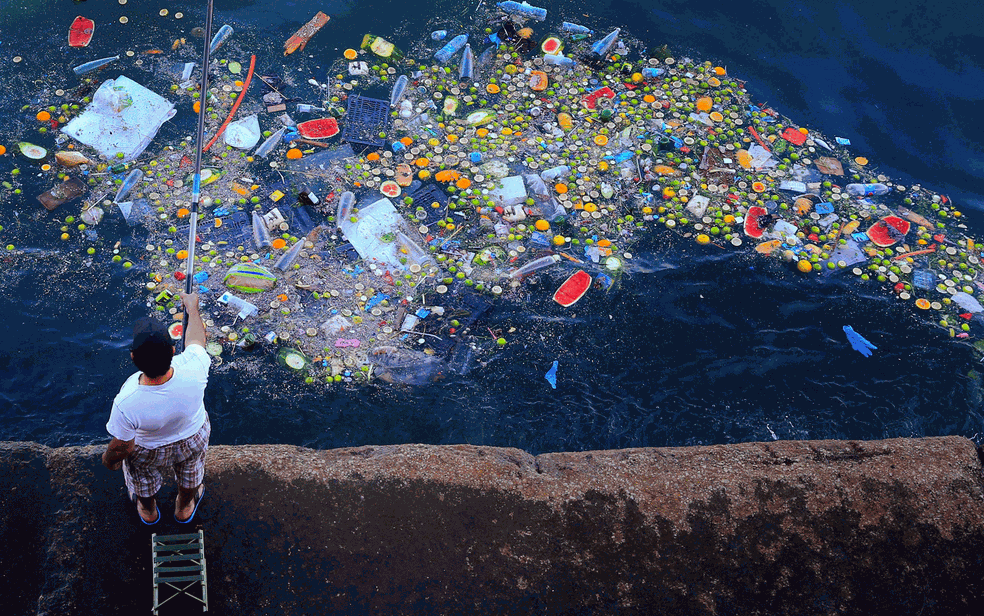 Homem pesca em meio ao lixo na costa do Mar MediterrÃ¢neo em Beirute, no LÃ­bano. (Foto: Hassan Ammar/AP/Arquivo)