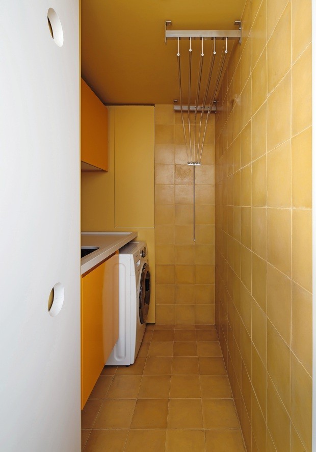 Varal de teto com varetas individuais na lavanderia projetada pelo escritório AR Arquitetos (Foto: Maíra Acayaba / Divulgação)