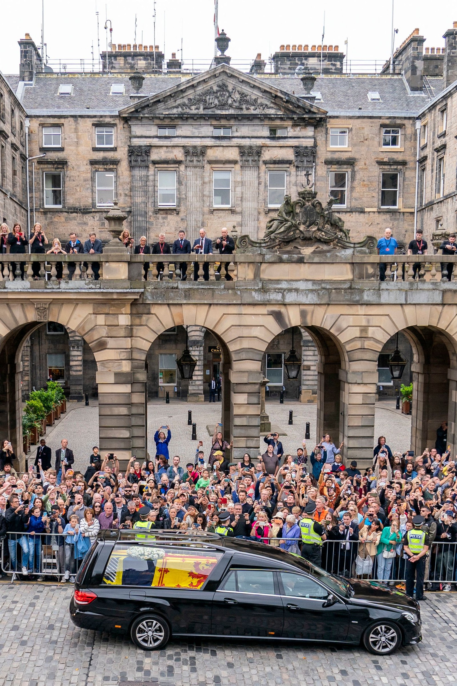 Público assiste ao carro funerário carregando o caixão da Rainha Elizabeth II, em Edimburgo — Foto: Jane Barlow / POOL / AFP