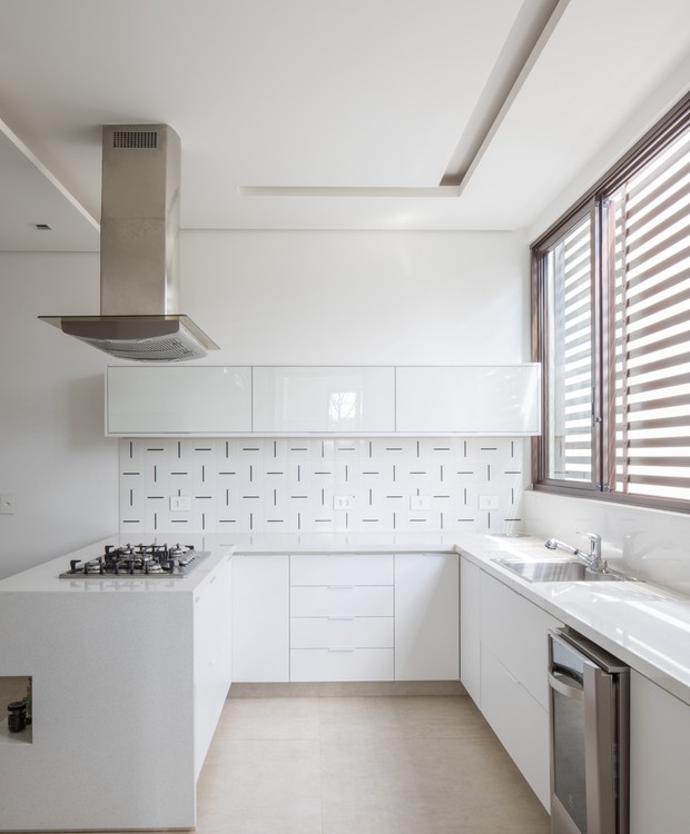 A cozinha toda branca tem azulejos decorativos da Lurca, granito da Multipedras e armários Kit House (Foto: Haruo Mikami)