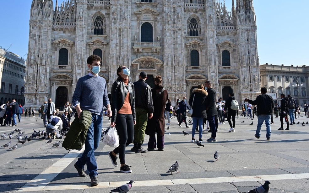 Pessoas usando máscaras caminham pela Piazza del Duomo, em Milão, na Itália, no sábado (17) — Foto: Miguel Medina/AFP