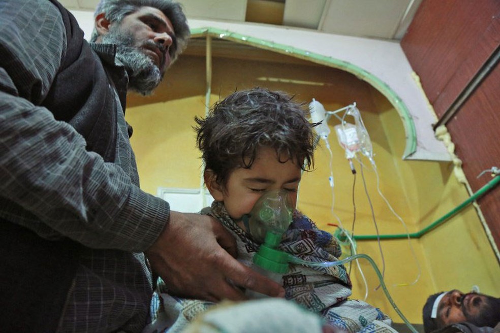 Criança recebe atendimento após ataque em al-Shifuniyah, em Guta Oriental, no domingo (25)  (Foto: Hamza Al-Ajweh / AFP )