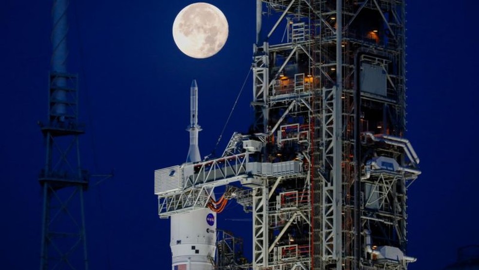 Imagem do nariz do foguete Artemis-i SLS, com a cpsula Orion, no prtico de lanamento,  luz da Lua — Foto: GETTY IMAGES via BBC