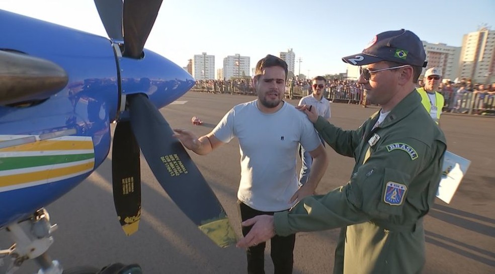 Rafael da Silva (de camiseta branca) teve a oportunidade de conhecer pessoalmente os modelos da Força Aérea disponíveis no evento (Foto: Reprodução/TV TEM)