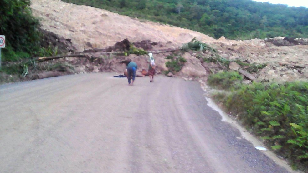 Moradores da Papua Nova Guiné inspecionam deslizamento de terra em uma estrada após terremoto na região no dia 26 de fevereiro de 2018  (Foto: Jerome Kay/Handout via Reuters)